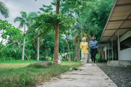 two women in hijab were seen jogging on the path in the parkの写真素材