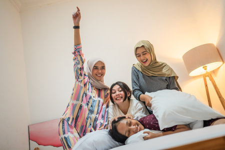 Friends share laughter and joyful moments during a fun pillow fight, creating memoriesの写真素材