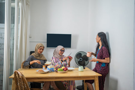 A family gathering occurs around a beautifully set table, sharing food, laughter, and memoriesの写真素材
