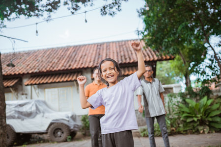 excited young kid playing with father and grandfather while raising fistの写真素材