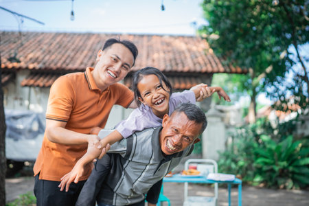 happy young girl piggyback by her grandfather, family conceptの写真素材