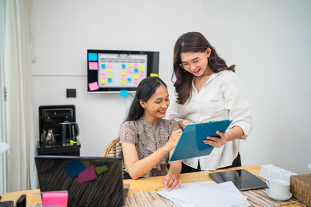 Two skilled professionals collaborating together in a modern and vibrant office environmentの写真素材