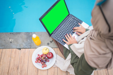 Imagine a serene poolside with a laptop and fresh fruits, ideal for a productive dayの写真素材