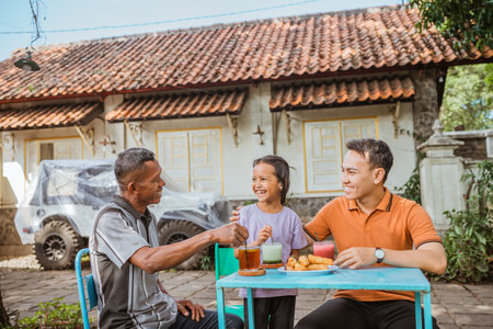 happy kid having meal with asian grandpa and dadの写真素材