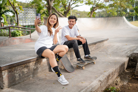 Friends enjoy a great day at the skatepark, making memories with a selfie togetherの写真素材