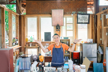 asian coffee shop waiter standing behind counter with open arm gesture