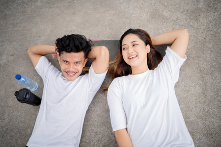 A young couple enjoying a sunny day on a skateboard, soaking up the sun and having funの写真素材