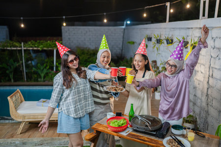 A cozy outdoor gathering with friends celebrating together on a delightful nightの写真素材