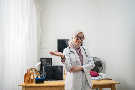 A female doctor smiles confidently in her medical office, showcasing her professionalism.の写真素材