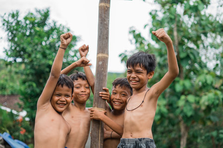 children are excited and laughing while standing in the betel nut climbing competitionの写真素材