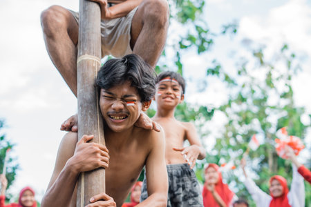 man endures having his shoulder stepped on an areca nut climbing event to celebrate Indonesian independenceの写真素材