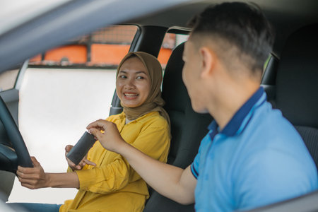 A young couple is happily sharing a joyful moment together in a car during their rideの写真素材