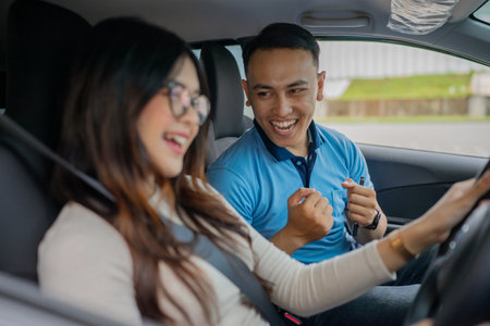 A joyful driving lesson that captures the smiles and learning journey inside a carの写真素材