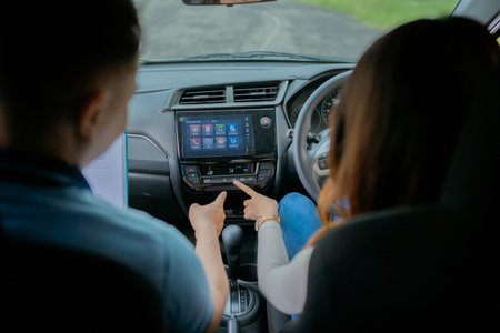Two individuals engaging with each other while utilizing a cars advanced infotainment systemの写真素材
