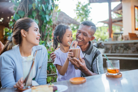 asian grandfather bonding with cute grandchild by having lunch togetherの写真素材