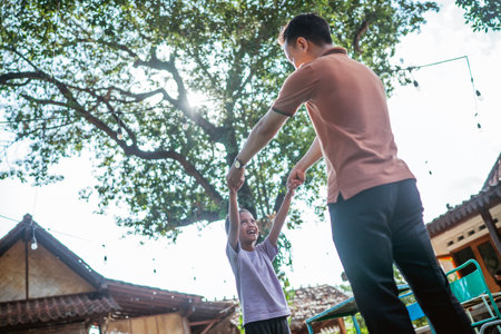 low angle view joyful young girl holding hands with her fatherの写真素材