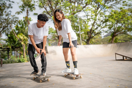 Two close friends are having a fantastic and enjoyable day skateboarding at the park togetherの写真素材
