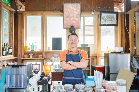 confident coffee shop waiter standing with crossed armの写真素材