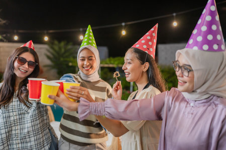 A group of friends joyfully enjoys a lively night party, sharing drinks and laughterの写真素材