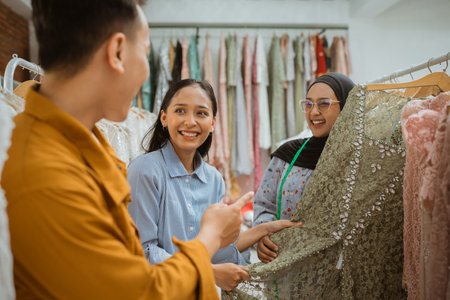 Customers are joyfully engaging and participating while selecting fabrics for fashion projectsの写真素材