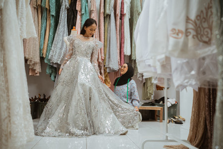 A beautiful bride admires her reflection in a stunning silver dress at a bridal boutiqueの写真素材