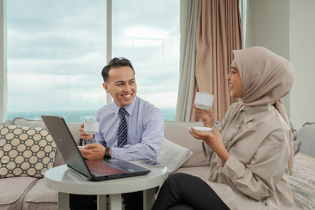 Two professionals are having a lively discussion in a modern office filled with natural lightの写真素材