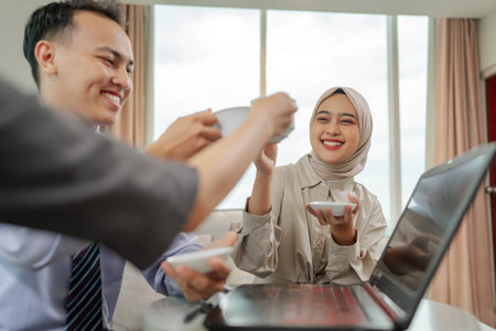Team members joyfully share coffee and warm smiles in a bright and welcoming office setting