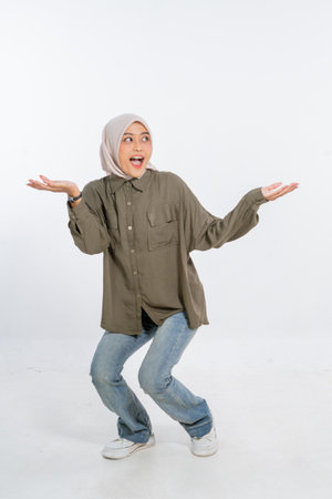 A cheerful and lively young woman is playfully striking a fun pose while dressed in casual clothingの写真素材