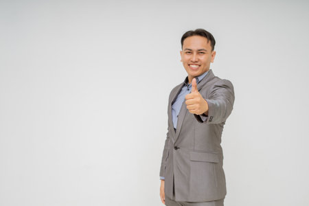 A confident businessman proudly shows his approval by giving a thumbs up gesture of positivityの写真素材