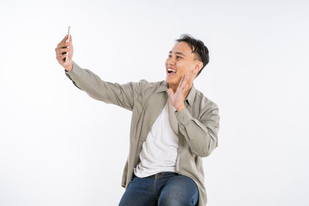 A cheerful man is enjoying a delightful selfie moment in a very bright and cheerful settingの写真素材