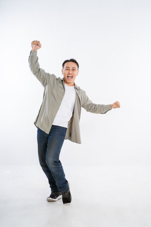 A joyful young man expresses his excitement through dance in an energetic studioの写真素材