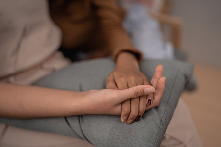 A closeup of two interlocked hands symbolizing connection and mutual support, showcasing a bondの写真素材