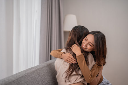 Two friends share a warm embrace, showcasing love and friendship in a modern space.
