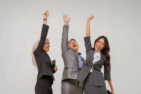 Three successful businesswomen celebrate their teams achievement and express enthusiasmの写真素材