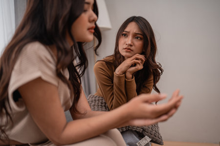 In a cozy indoor setting, two women engage in a deep conversation about important matters and lifeの写真素材