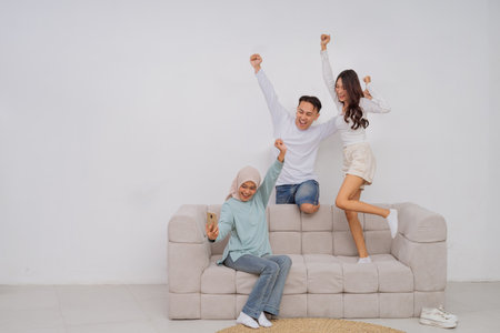 A happy family shares a joyful moment together on their cozy couch, celebrating their loveの写真素材