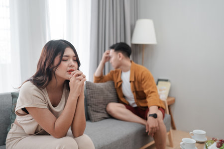 A couple experiences tension during a conversation at home, reflecting emotional distress.の写真素材