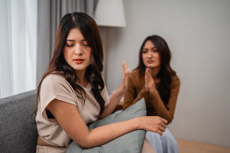 Two close friends share an emotional moment discussing feelings in a cozy settingの写真素材