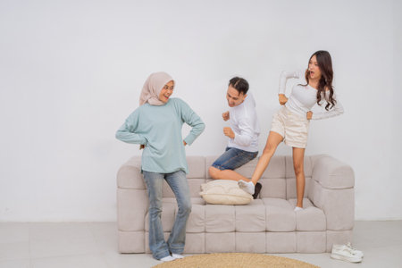 A lively group of friends joyfully sharing cheerful moments together on a soft, cozy sofaの写真素材