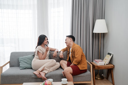 A loving couple shares laughter and meaningful conversation in their cozy living roomの写真素材