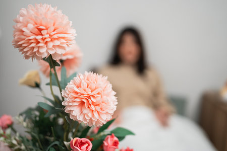 A beautifully soothing indoor setting adorned with vibrant flowers and a calm figure nearbyの写真素材