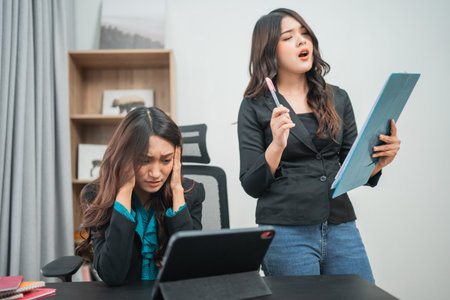 A tense moment in an office as one woman presents passionately while another looks stressed.の写真素材