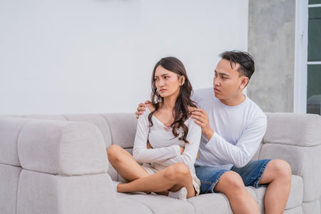 A young couple navigates emotional tension during a deep sofa conversation, struggling to connectの写真素材