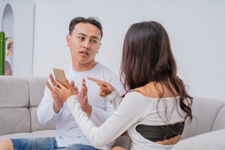 A couple engages in a lively discussion while closely examining a smartphone togetherの写真素材