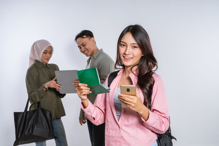 Friends plan their travels using digital devices and documents for an enjoyable experienceの写真素材