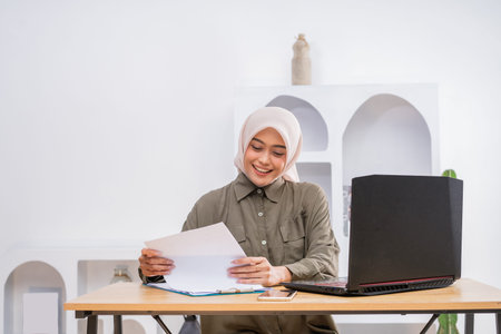 A dedicated female professional working with important documents in a stylish home workspace