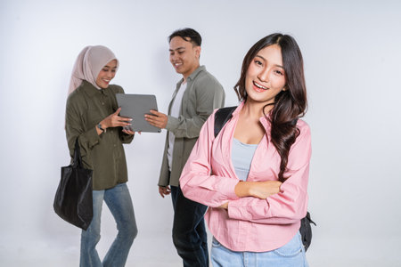 A confident young woman poses with friends, showcasing teamwork and modernity in joyの写真素材