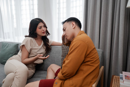 A young couple is engaged in a serious discussion about important matters at homeの写真素材