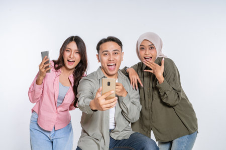 Three close friends happily take a spontaneous selfie, showcasing their strong bondの写真素材