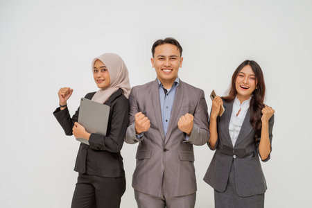 Three professionals celebrating a successful achievement together in an office setting.の写真素材